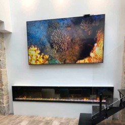 Cheminée électrique Ignite XL installée sur un mur blanc sous un tableau coloré