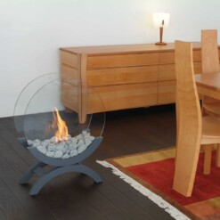 Cheminée bioéthanol à poser au sol ALFRA EVA-4 en couleur gris souris à côté d'une table à manger