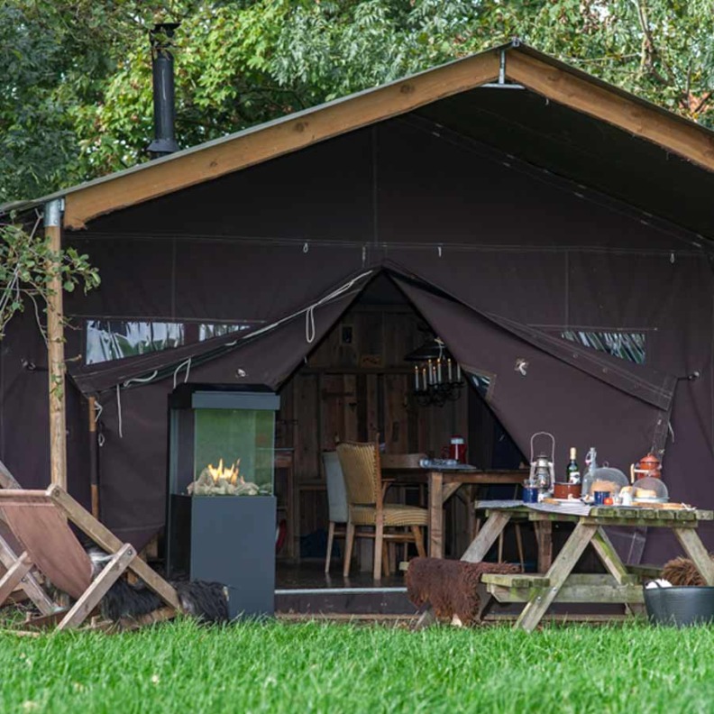 Cheminée à gaz TheBuzz de Faber installée devant une tente