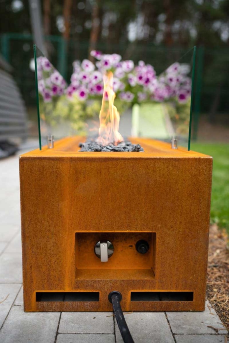 Cheminée à gaz à poser au sol Galio cornet de Planika vue de profil avec la flamme au centre des décorations