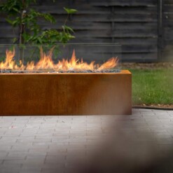 Cheminée à gaz d'extérieur Galio corten en fonctionnement en bord de terasse