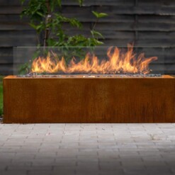 Cheminée à gaz d'extérieur Galio corten posée devant un jardin