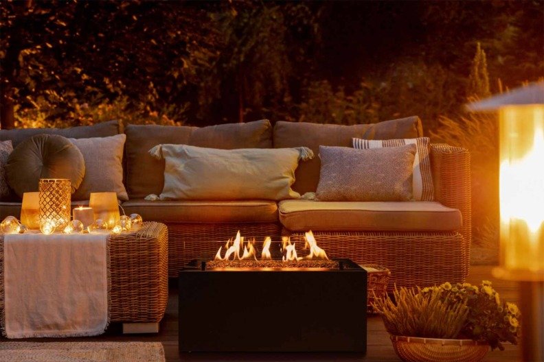 Ambiance cosy sur une terrasse avec la flamme de la cheminée à gaz Rio