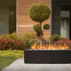 Cheminée à gaz Galio en évidence au milieu d'un jardin aménagé