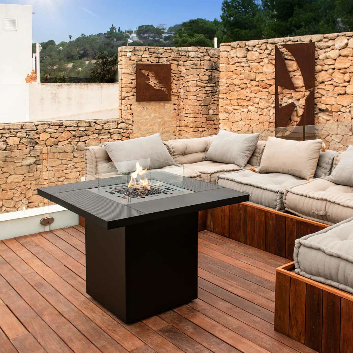 Cheminée à gaz Square Table de Planika installée devant des meubles d'extérieur