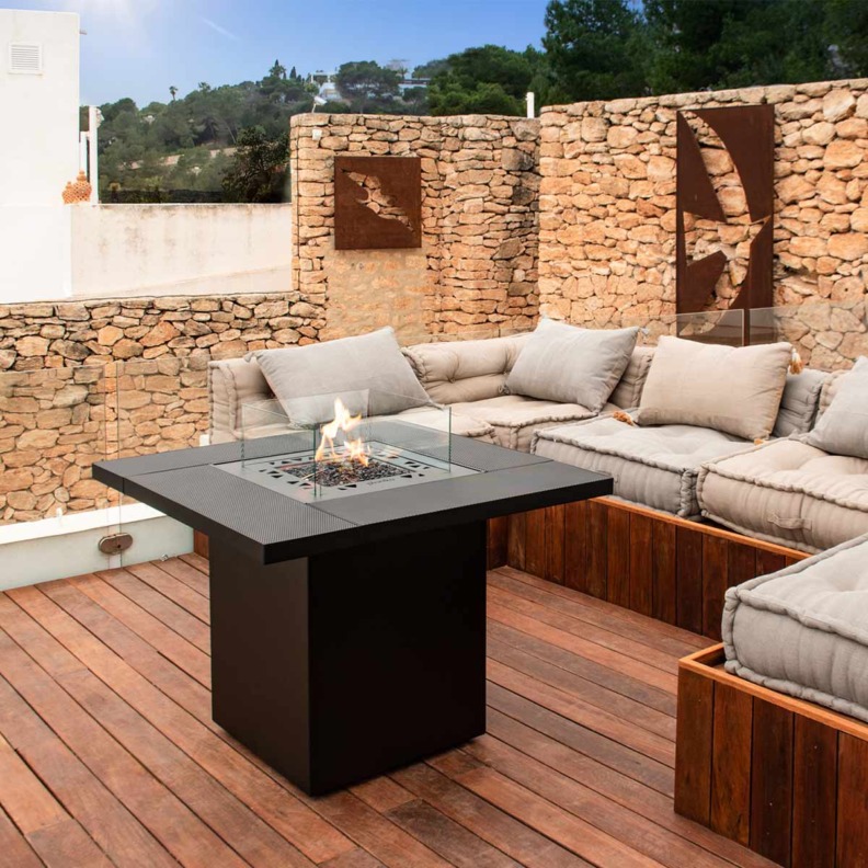 Cheminée à gaz Square Table de Planika installée devant des meubles d'extérieur