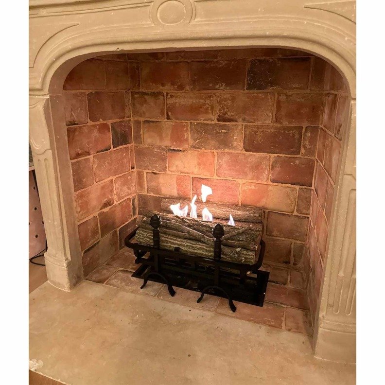 Cheminée Changy Pomme de Pin placée au centre d'une cheminée