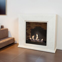 Cheminée Nero de Xaralyn en version bioéthanol avec fond brique et médaillon effet plaque fonte